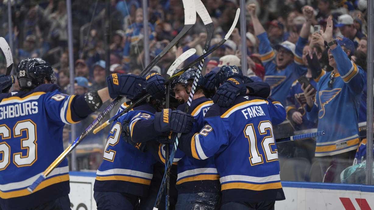 St. Louis Blues' Philip Broberg, second from right, is congratulated by teammate after scoring the game-winning goal in overtime of an NHL hockey game against the Vancouver Canucks Thursday, March 20, 2025, in St. Louis.