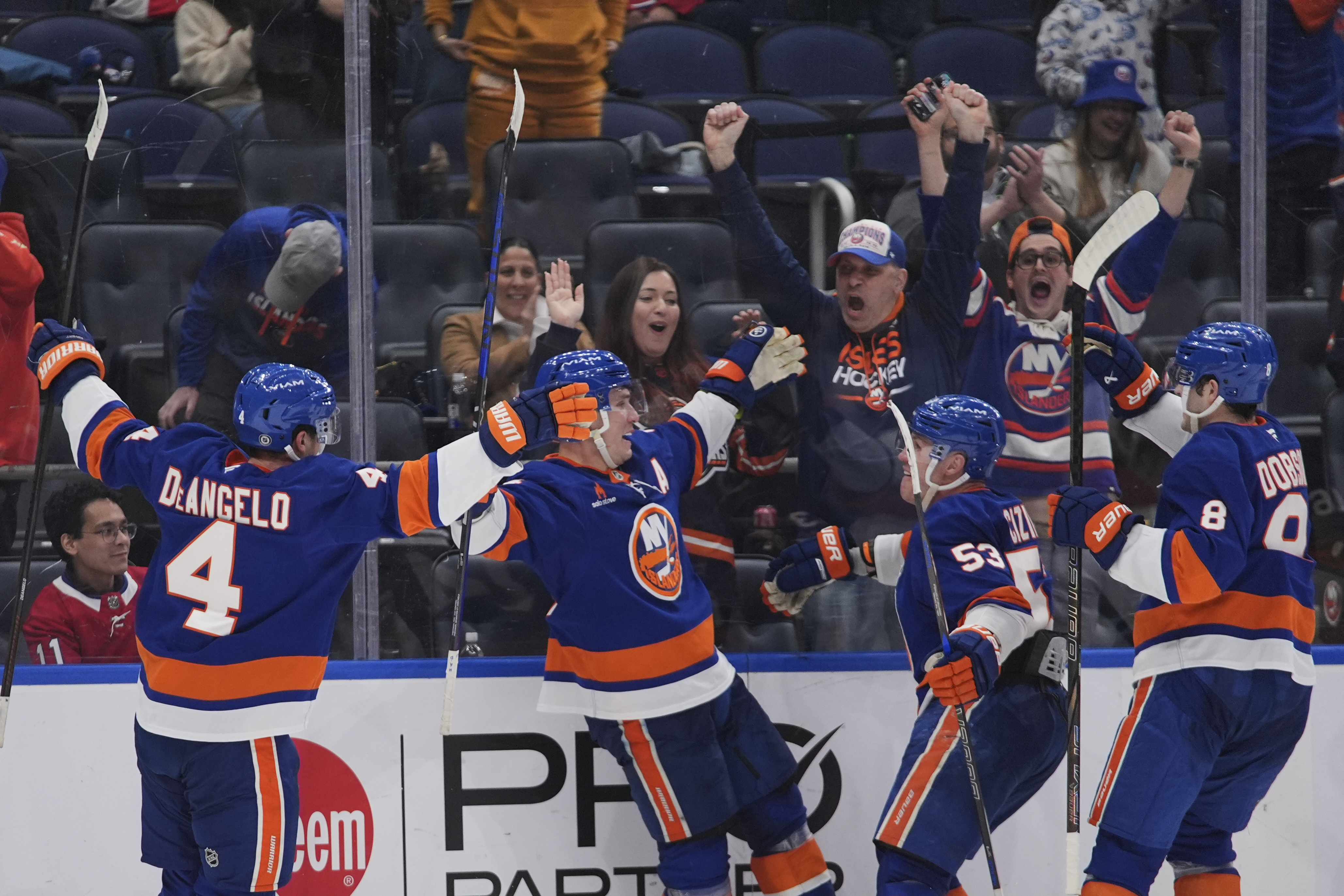 New York Islanders' Bo Horvat celebrates with teammates Tony DeAngelo (4), Casey Cizikas (53) and Noah Dobson (8) after scoring the game-winning goal during the overtime period of an NHL hockey game against the Montreal Canadiens Thursday, March 20, 2025, in Elmont, N.Y.