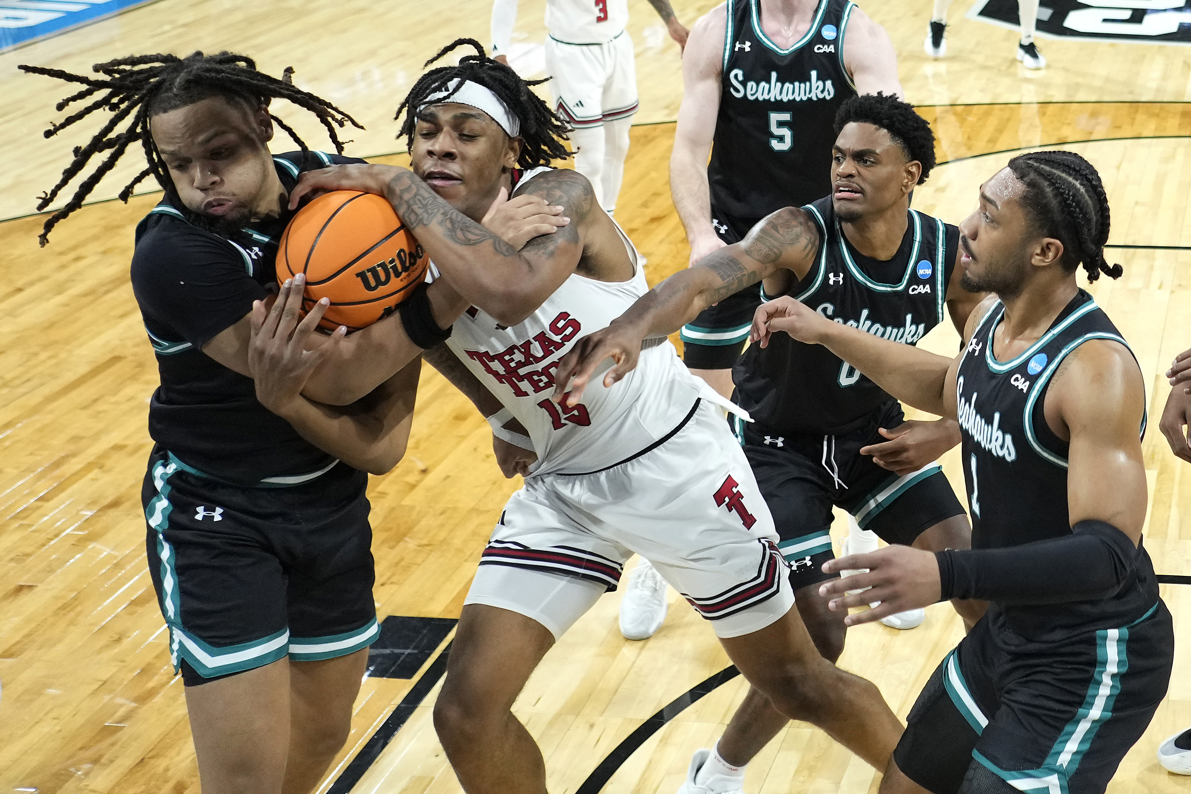 UNC Wilmington guard Greedy Williams, left, and Texas Tech forward JT Toppin (15) compete for a rebound during the first half of the first round of the NCAA college basketball tournament, Thursday, March 20, 2025, in Wichita, Kan.