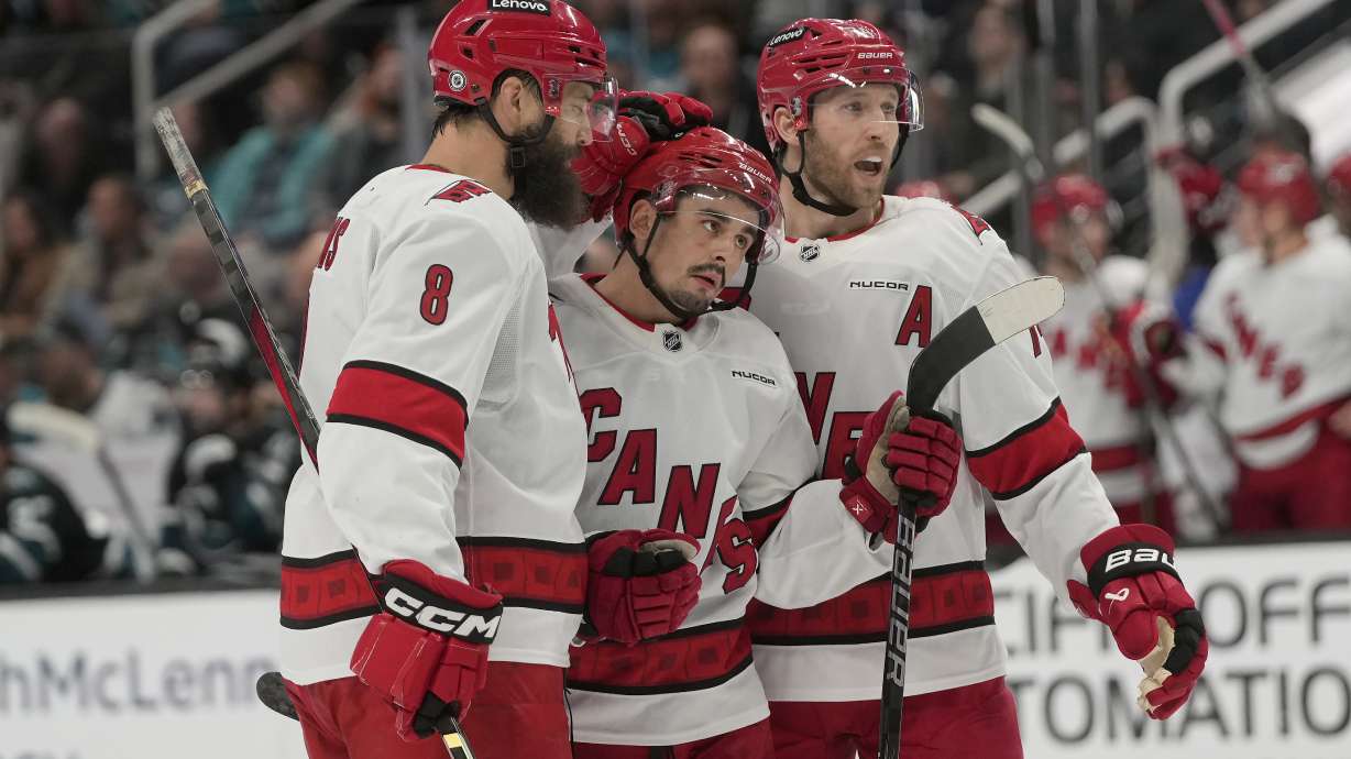 Carolina Hurricanes center Seth Jarvis, middle, is congratulated by defenseman Brent Burns, left, and defenseman Jaccob Slavin after scoring against the San Jose Sharks during the second period of an NHL hockey game in San Jose, Calif., Thursday, March 20, 2025.