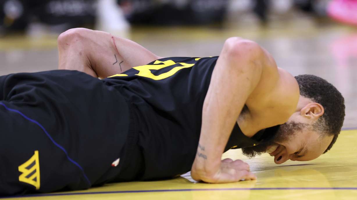 Golden State Warriors' Stephen Curry grimaces in pain after a rough landing in the 3rd quarter against Toronto Raptors during NBA game at Chase Center in San Francisco on Thursday, March 20, 2025.