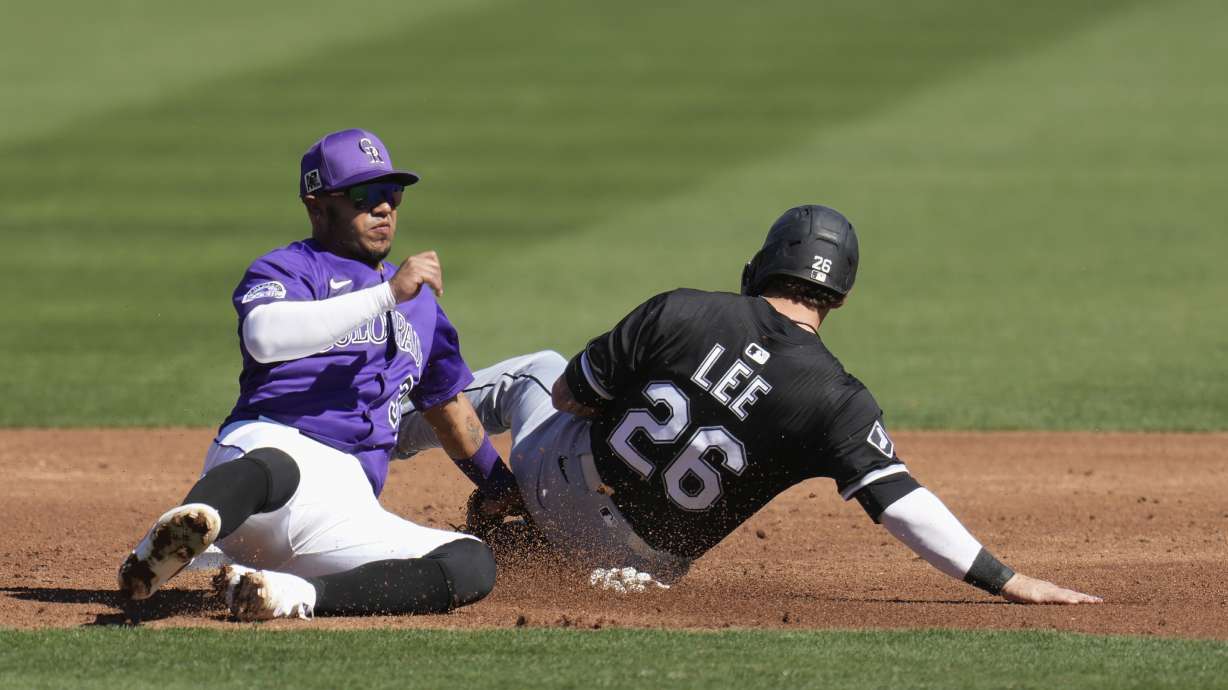 Chicago White Sox's Korey Lee (26) steals second base as Colorado Rockies second baseman Thairo Estrada loses control of the ball during the third inning of a spring training baseball game Tuesday, Feb. 25, 2025, in Scottsdale, Ariz.