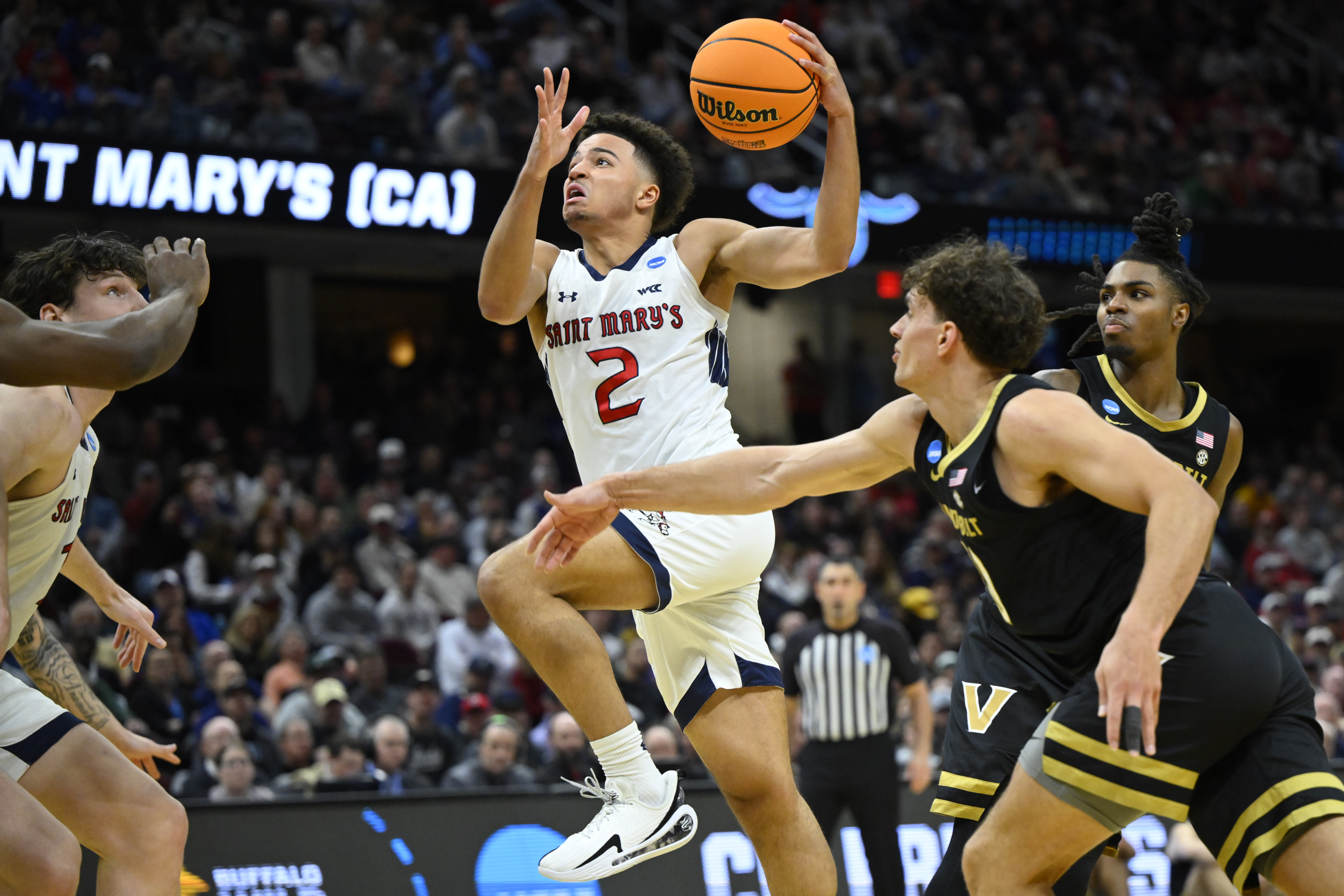 Saint Mary's guard Jordan Ross (2) drives to the basket past Vanderbilt guard Chris Manon, second from right, and guard Jason Edwards in the first half in the first round of the NCAA college basketball tournament, Friday, March 21, 2025, in Cleveland.