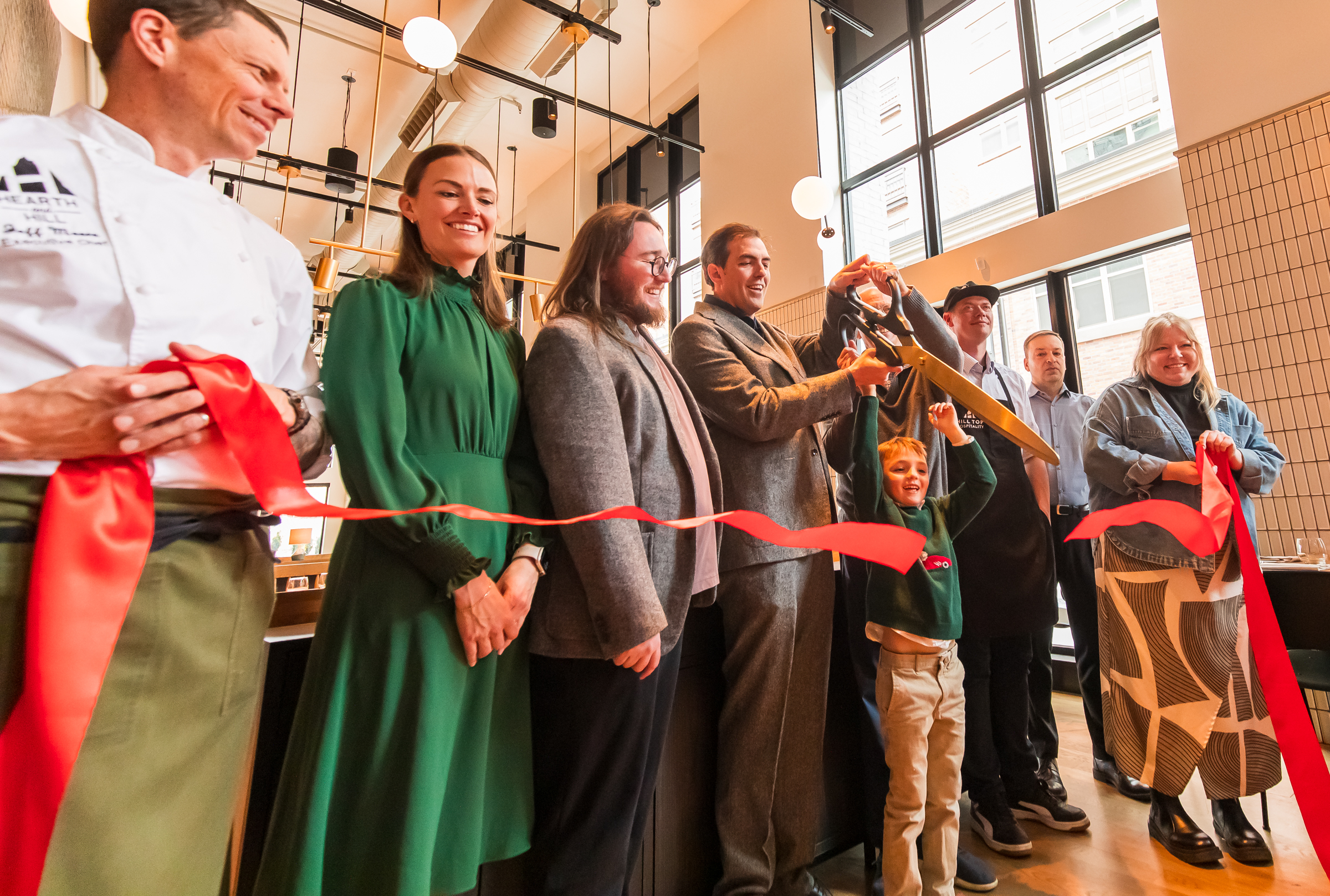 Brooks Kirchheimer cuts a ribbon alongside his family and Hearth and Hill staff during a ceremony at the Salt Lake City restaurant on Friday.