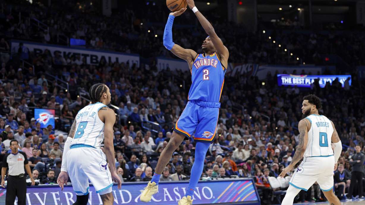 Oklahoma City Thunder guard Shai Gilgeous-Alexander (2) looks to shoot over Charlotte Hornets guard Nick Smith Jr. (8) as Hornets forward Miles Bridges (0) watches during the first half of an NBA basketball game Friday, March 21, 2025, in Oklahoma City.