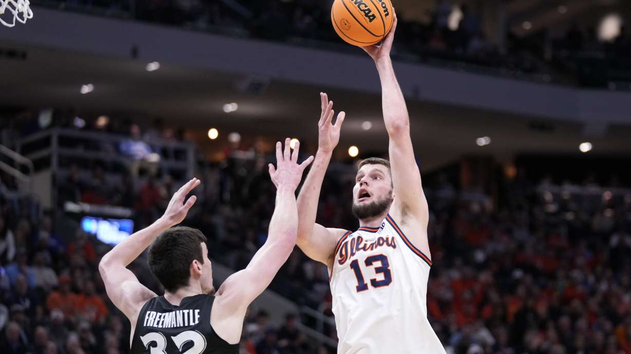 Illinois center Tomislav Ivisic (13) scores against Xavier forward Zach Freemantle (32) during the first half in the first round of the NCAA college basketball tournament, Friday, March 21, 2025, in Milwaukee.