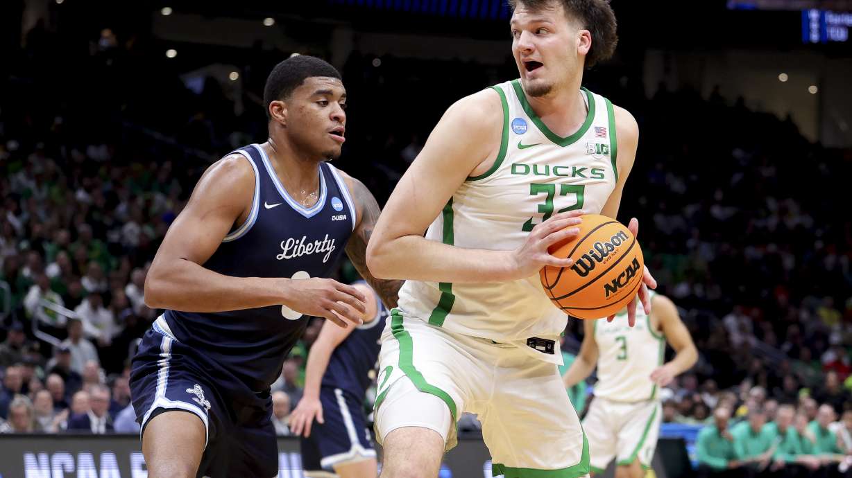 Oregon center Nate Bittle, right, drives against Liberty forward Owen Aquino during the first half in the first round of the NCAA college basketball tournament, Friday, March 21, 2025, in Seattle.