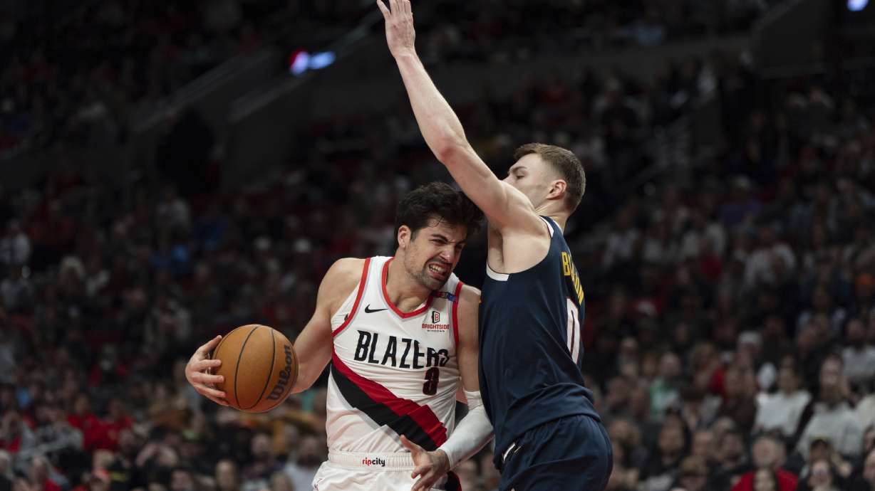 Portland Trail Blazers forward Deni Avdija (8) tries to get around Denver Nuggets guard Christian Braun (0) during the second half of an NBA basketball game Friday, March 21, 2025, in Portland, Ore.