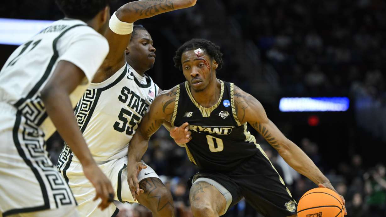 Michigan State forward Coen Carr (55) defends Bryant guard Earl Timberlake (0) in the first half in the first round of the NCAA college basketball tournament, Friday, March 21, 2025, in Cleveland.