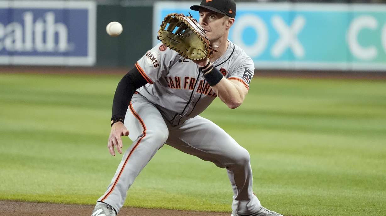 FILE - San Francisco Giants first baseman Mark Canha fields a ground ball hit by Arizona Diamondbacks' Jose Herrera before throwing to first base for an out during the third inning of a baseball game, Sept. 23, 2024, in Phoenix.