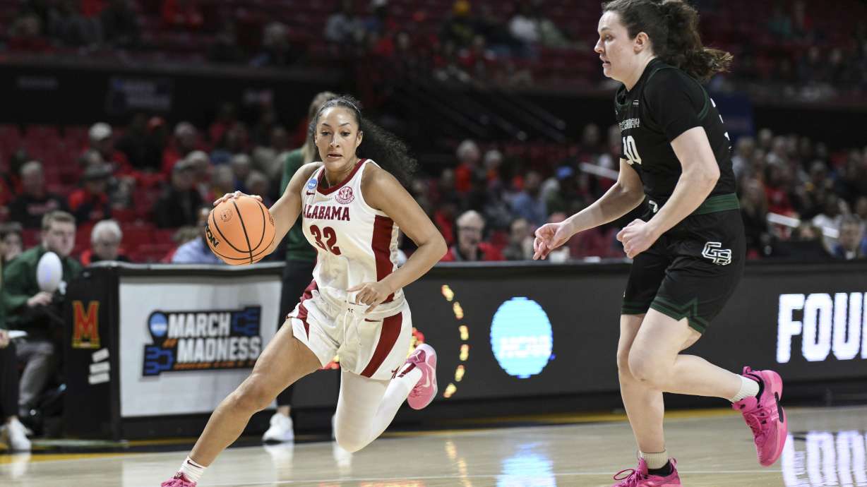 Alabama guard Aaliyah Nye (32) drives to the basket as Green Bay center Jenna Guyer defends during the first half in the first round of the NCAA college basketball tournament, in College Park, Md. Saturday, March 22, 2025.