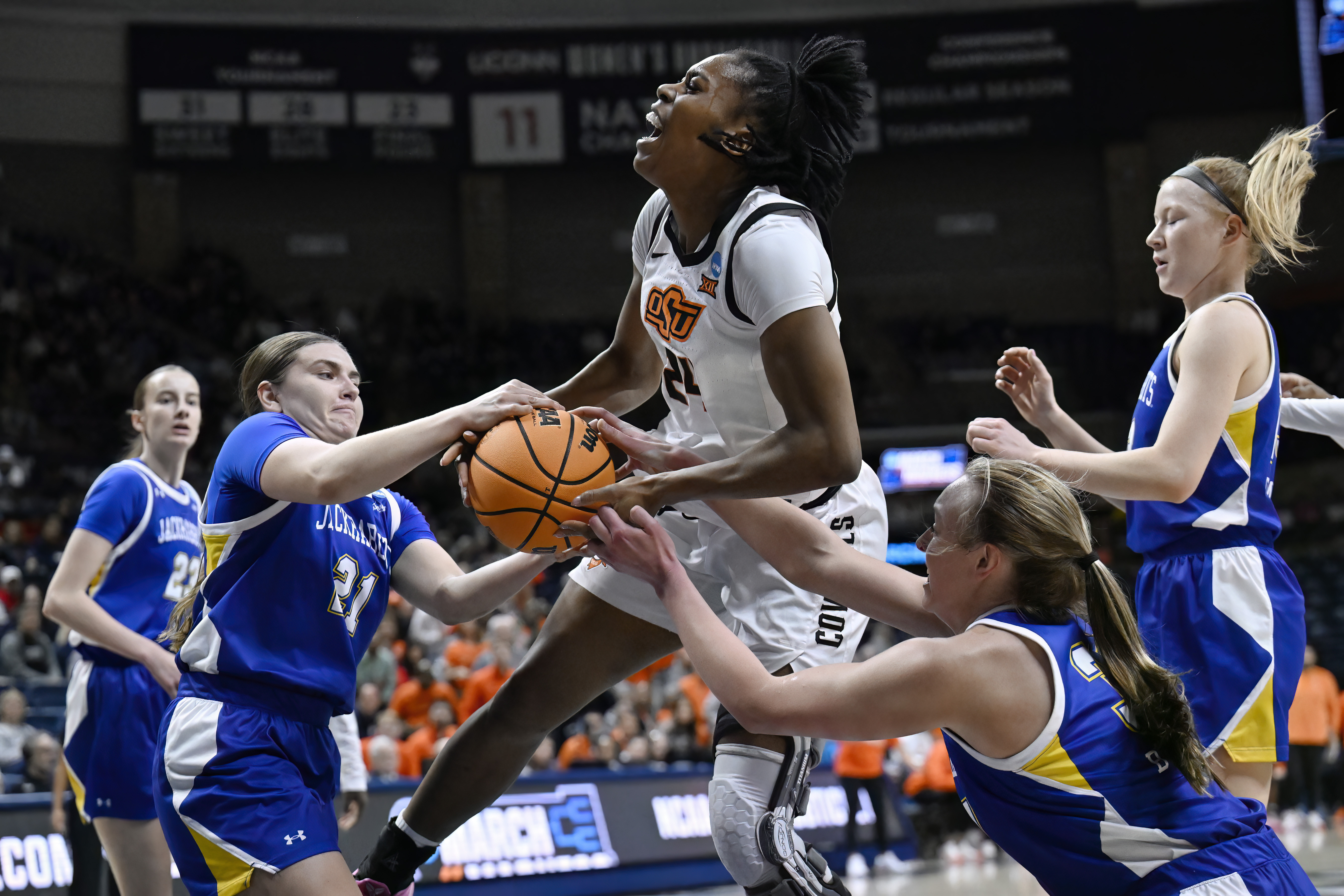 Oklahoma State forward Praise Egharevba, center, is pressured by South Dakota State guard Paige Meyer, left, and South Dakota State forward Brooklyn Meyer, right, during the first half in the first round of the NCAA college basketball tournament, Saturday, March 22, 2025, in Storrs, Conn.