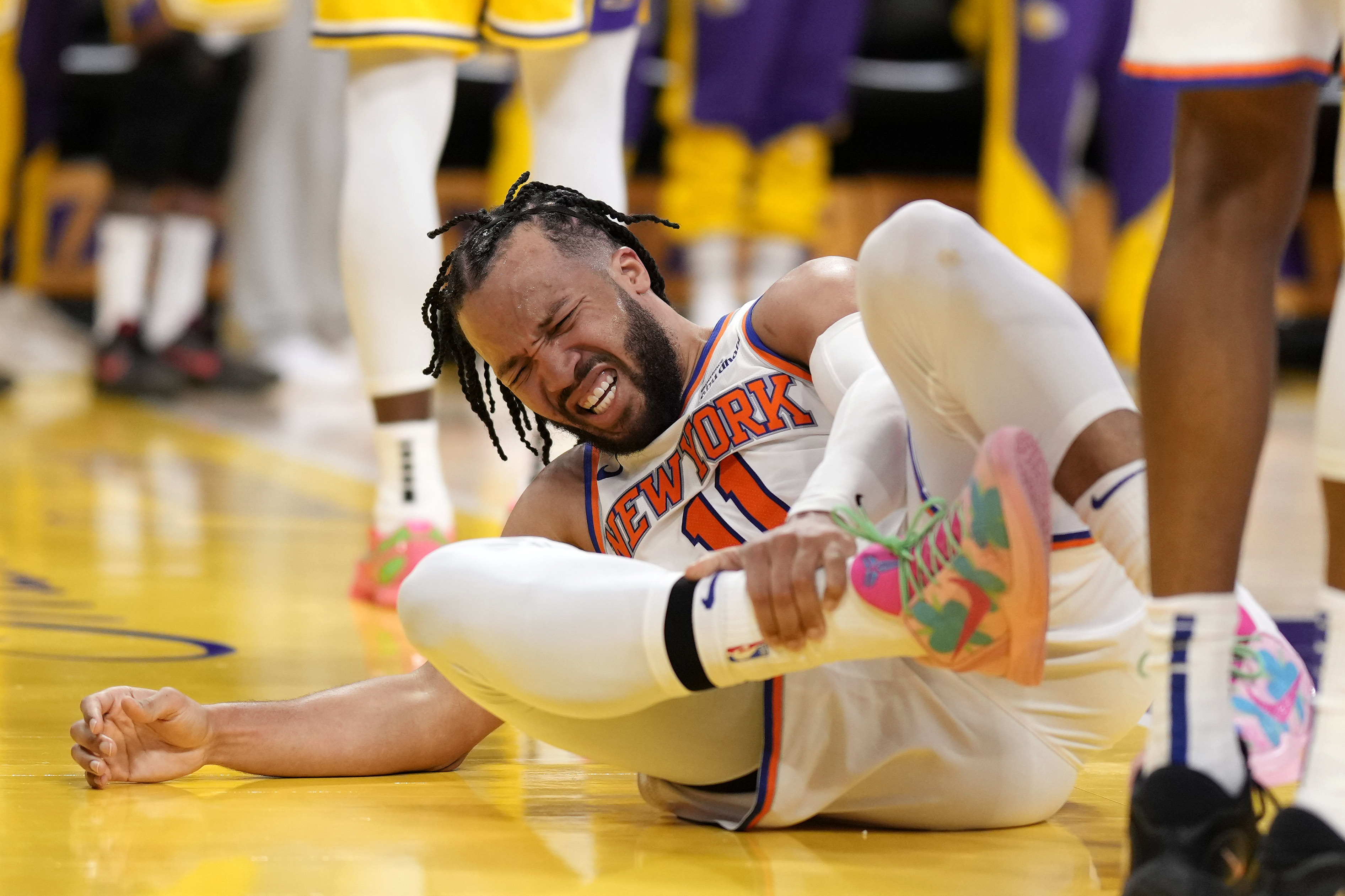 New York Knicks guard Jalen Brunson writhes in pain after getting injured during the second half of an NBA basketball game against the Los Angeles Lakers, Thursday, March 6, 2025, in Los Angeles.