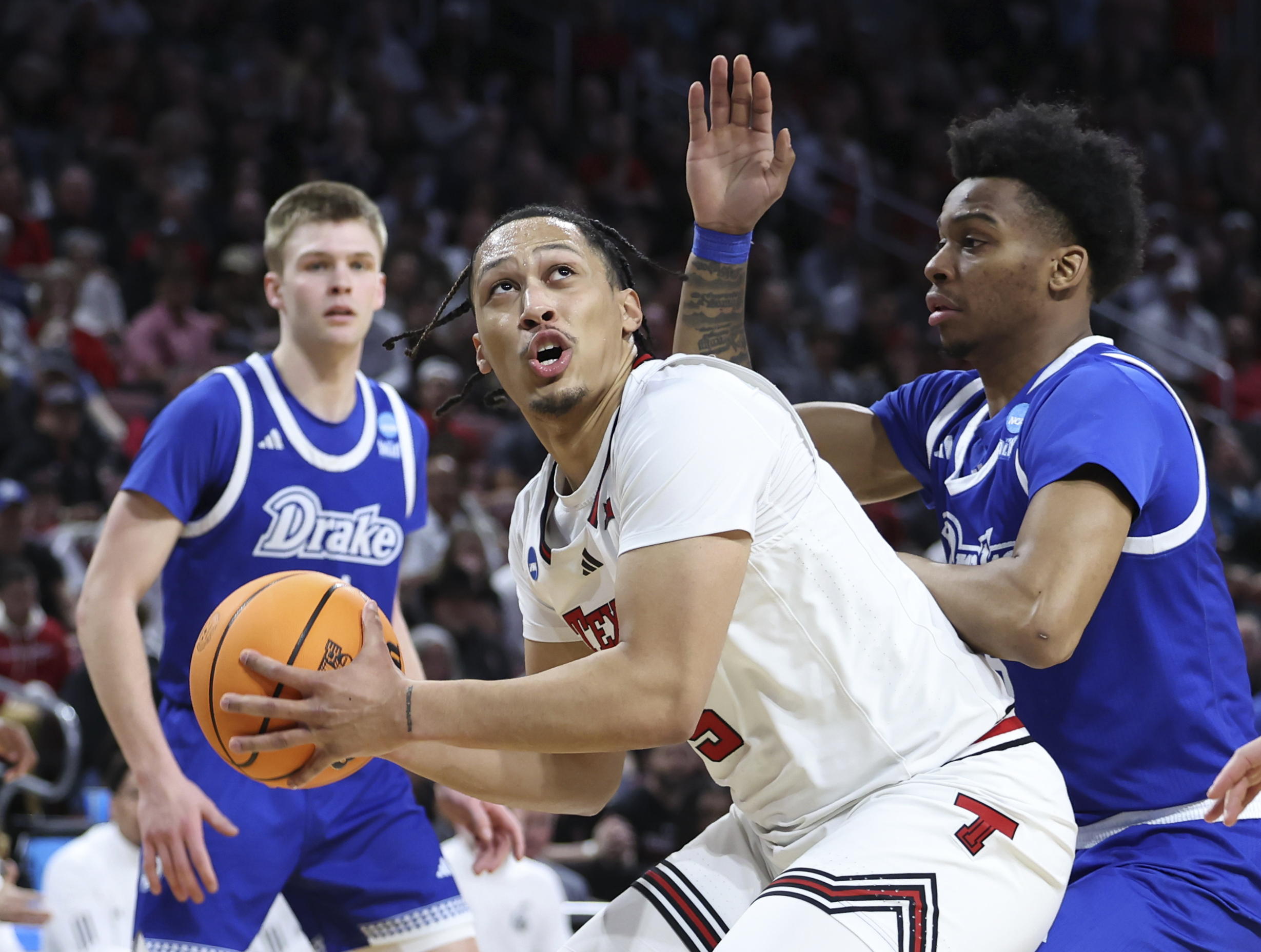 Texas Tech forward Darrion Williams (5) looks for a path to the basket against Drake guard Tavion Banks, right, during the first half in the second round of the NCAA college basketball tournament, Saturday, March 22, 2025, in Wichita, Kan. 