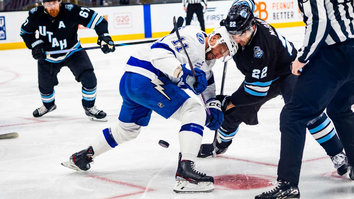 Utah Hockey Club center Jack McBain (22) and Tampa Bay Lightning center Luke Glendening (11) face-off during an NHL game at the Delta Center in Salt Lake City on Saturday, March 22, 2025.