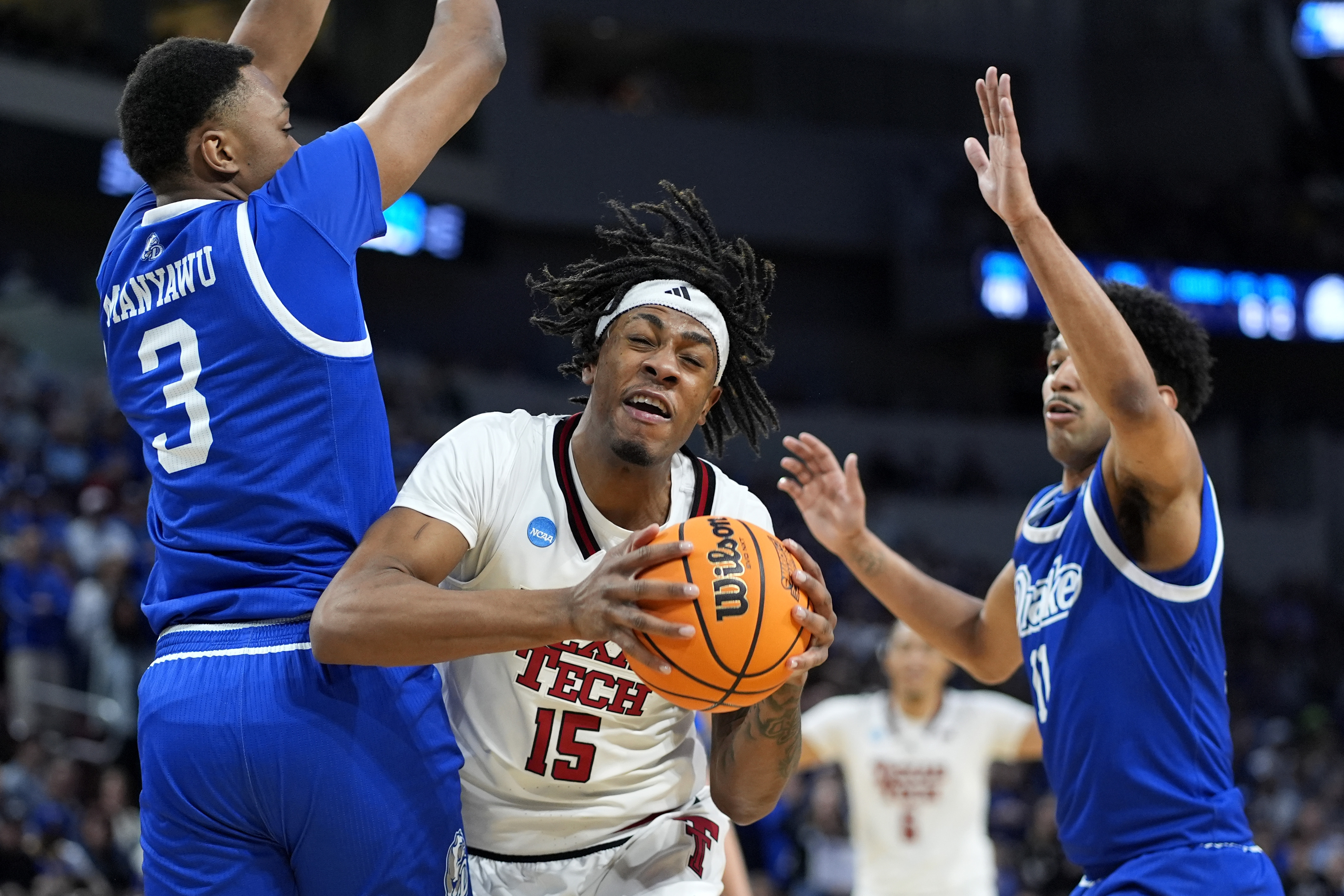 Texas Tech forward JT Toppin (15) gets between Drake forward Cam Manyawu (3) and guard Kael Combs (11) during the second half of the second round of the NCAA college basketball tournament, Saturday, March 22, 2025, in Wichita, Kan.