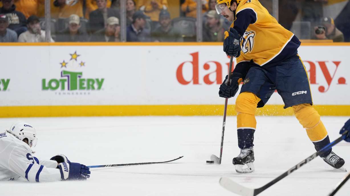 Nashville Predators left wing Filip Forsberg, right, shoots the puck past Toronto Maple Leafs defenseman Chris Tanev, left, during the second period of an NHL hockey game Saturday, March 22, 2025, in Nashville, Tenn.