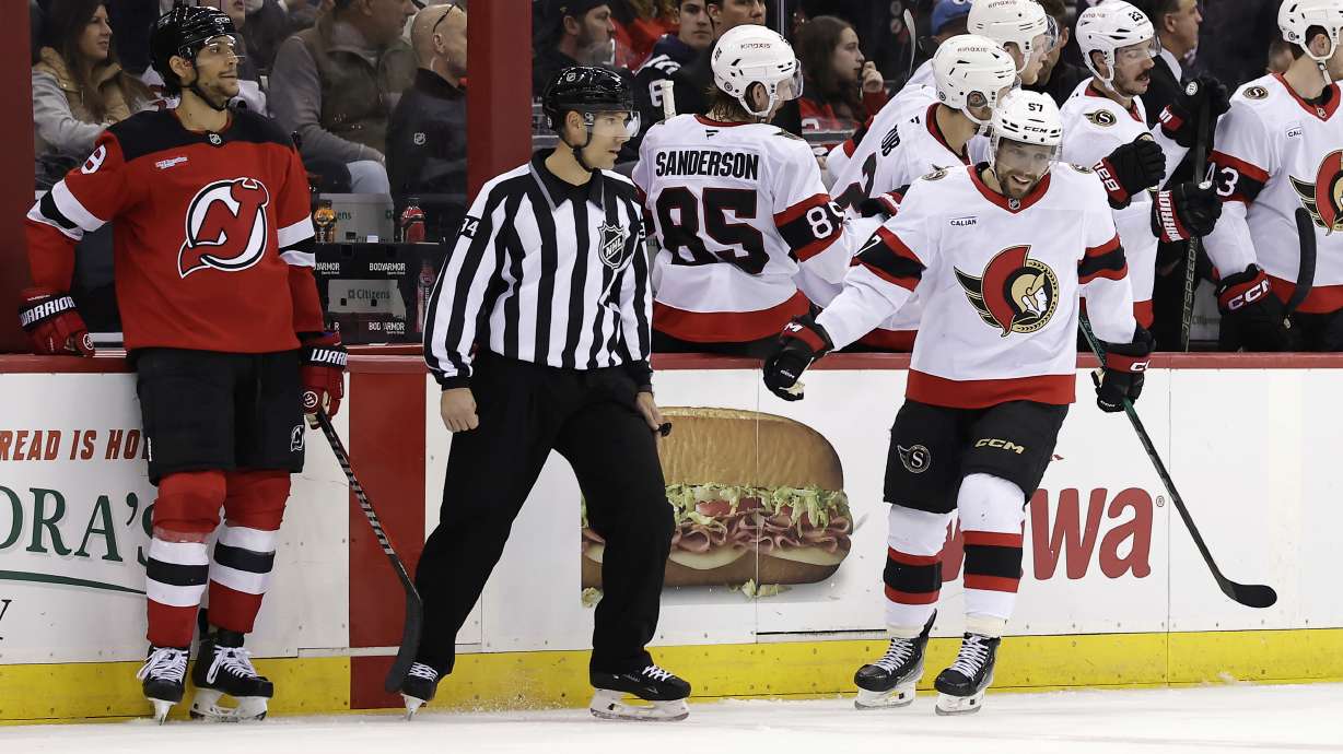 Ottawa Senators left wing David Perron (57) celebrates with teammates after scoring a goal during the second period of an NHL hockey game as New Jersey Devils defenseman Johnathan Kovacevic, left, looks on Saturday, March 22, 2025, in Newark, N.J.