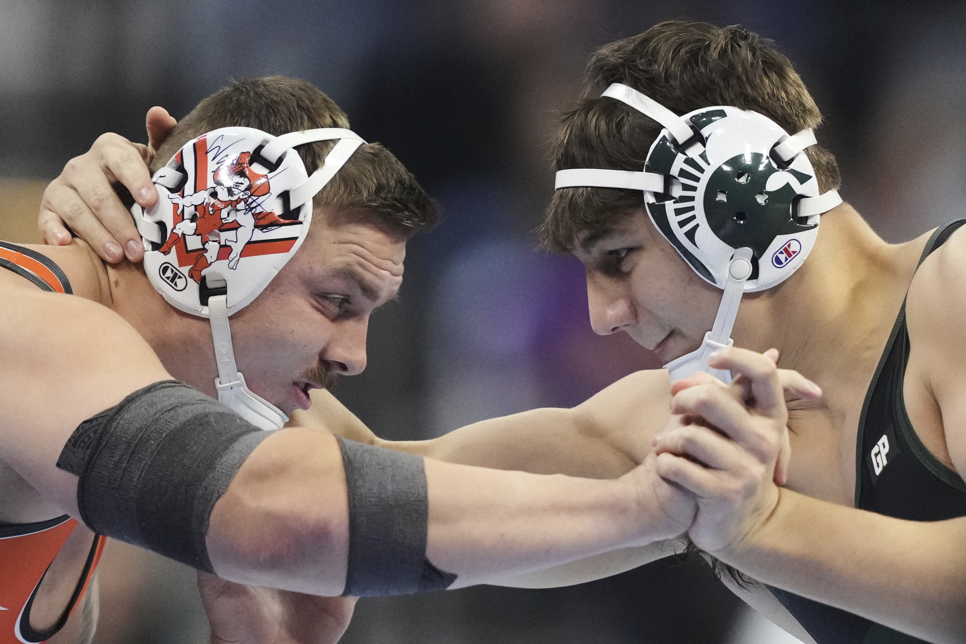 Oklahoma State's Wyatt Hendrickson, left, takes on Michigan State's Max Vanadia in their CCC-pound first round match during the NCAA wrestling championships, Thursday, March 20, 2025, in Philadelphia.
