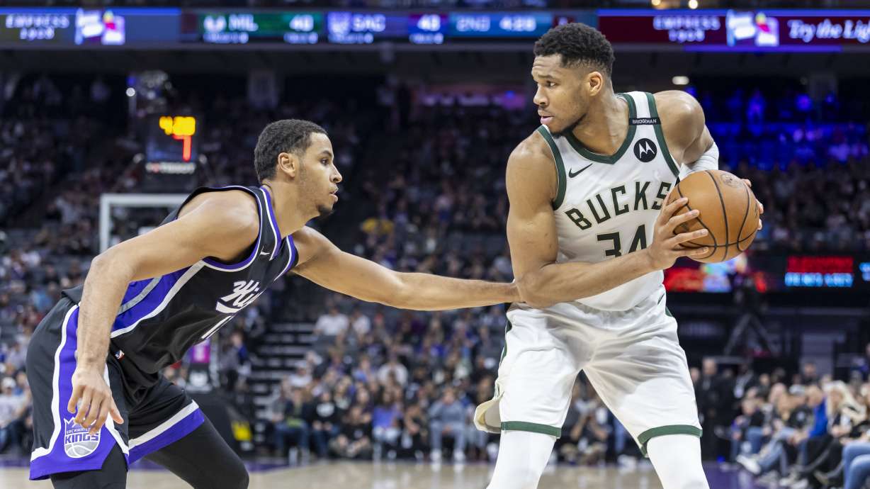 Milwaukee Bucks forward Giannis Antetokounmpo (34) looks to pass the ball as Sacramento Kings forward Keegan Murray, left, defends during the first half of an NBA basketball game Saturday, March 22, 2025, in Sacramento, Calif.