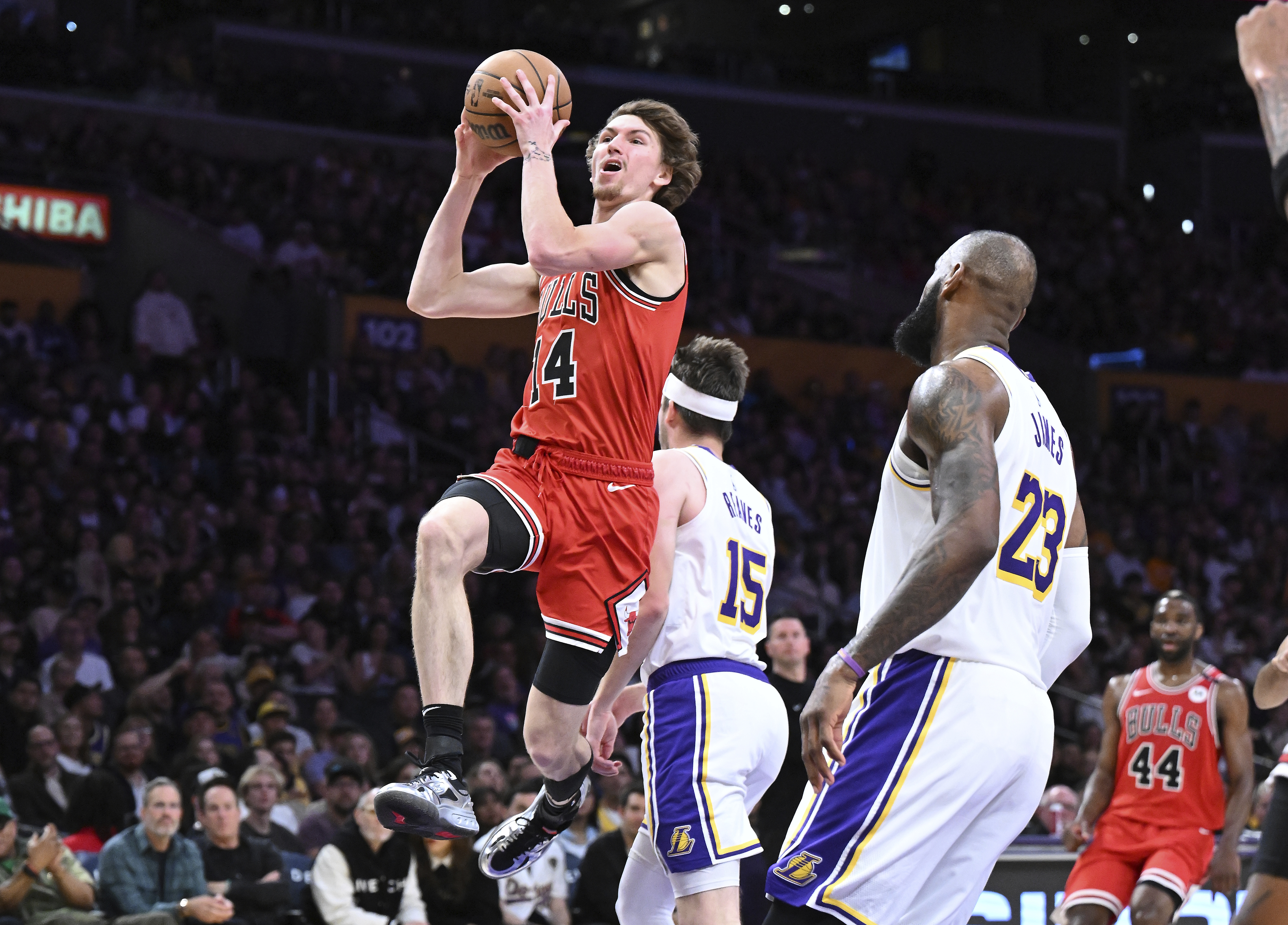Chicago Bulls forward Matas Buzelis (14) scores a basket in front of Los Angeles Lakers forward LeBron James (23) in the first half of an NBA basketball game Saturday, March 22, 2025, in Los Angeles.
