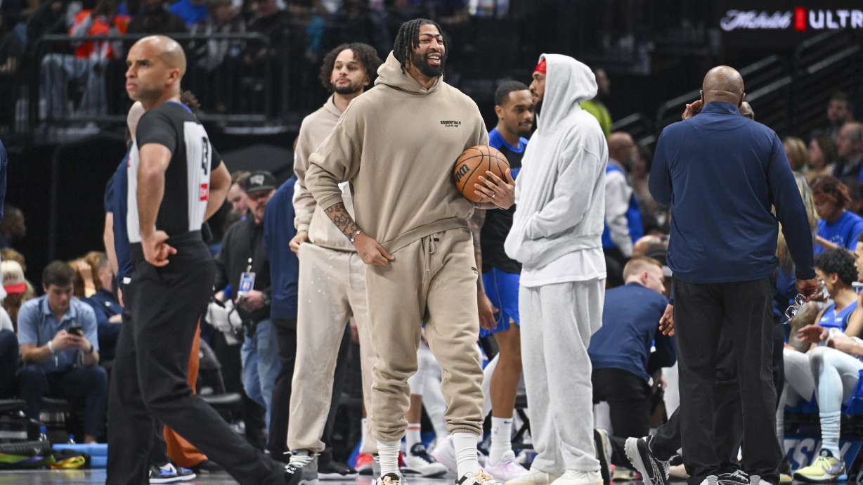 Dallas Mavericks' Anthony Davis, center, in street clothes due to an injury, looks on during the first half of an NBA basketball game against the Detroit Pistons, Friday, March 21, 2025, in Dallas, Texas.