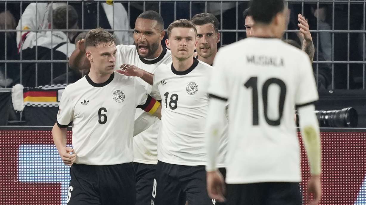 Germany's Joshua Kimmich, left, celebrates with teammates after scoring opening goal during the Nations League quarterfinal second leg soccer match between Germany and Italy at the Signal-Iduna Park in Dortmund, Germany, Sunday, March 23, 2025.