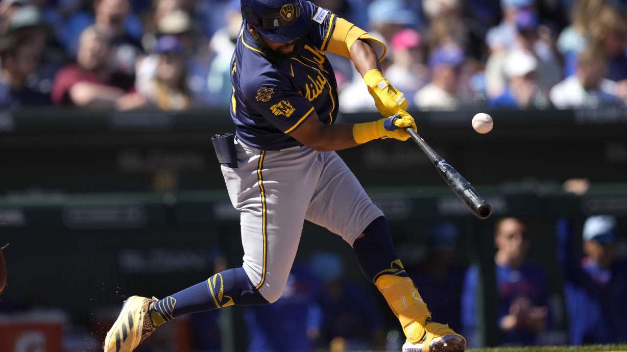 Milwaukee Brewers' Manuel Margot connects for a base hit against the Chicago Cubs during the first inning of a spring training baseball game, Tuesday, March 11, 2025, in Mesa, Ariz.