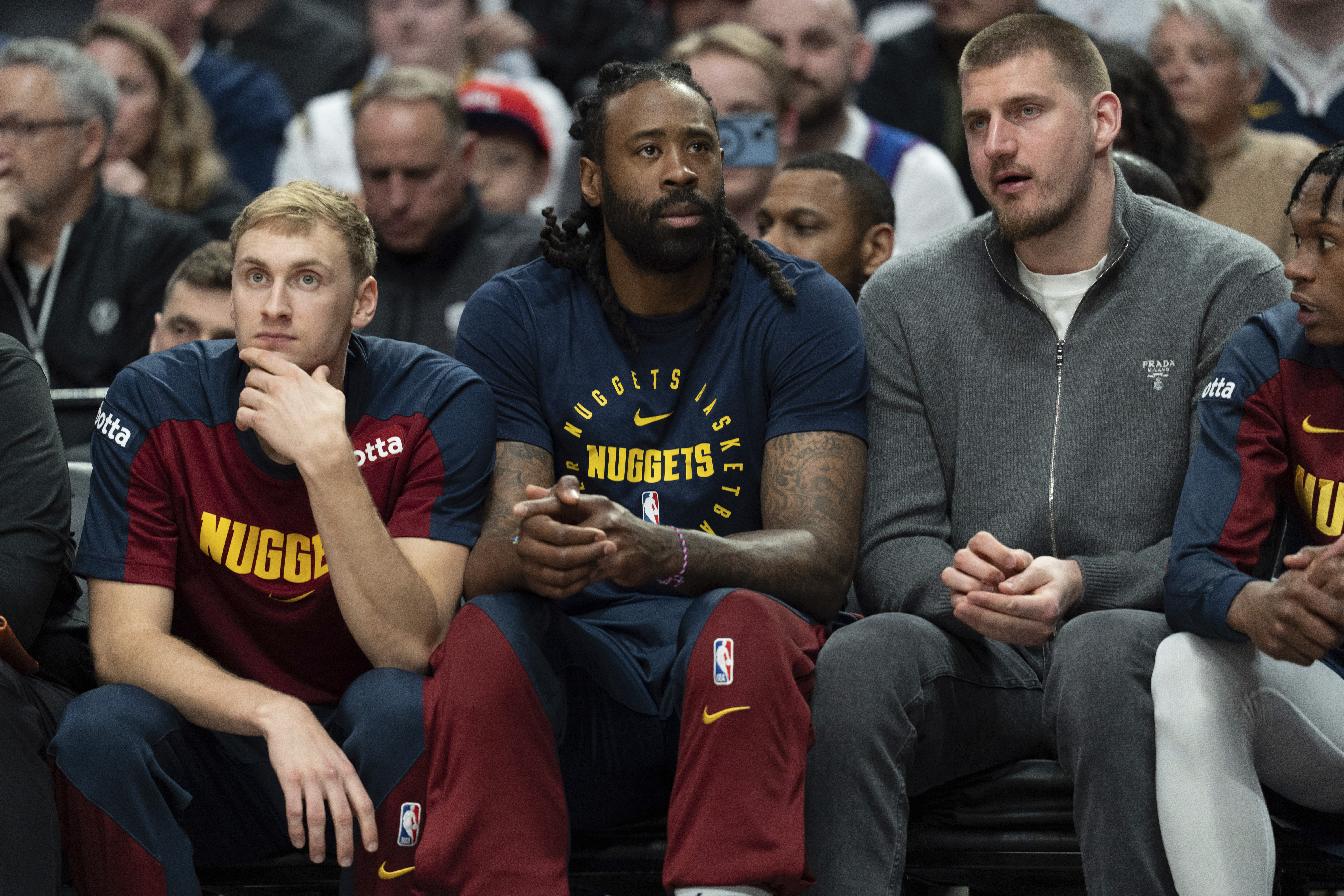 Denver Nuggets center Nikola Jokic, right, talks with Denver Nuggets center DeAndre Jordan, second from left, while on the bench during the first half of an NBA basketball game against the Portland Trail Blazers, Friday, March 21, 2025, in Portland, Ore.
