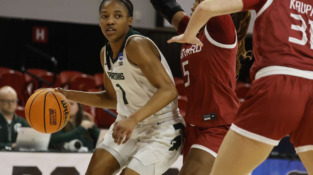 Michigan State's Jaddan Simmons (1) tries to move the ball past Harvard's Gabby Anderson (5) and Katie Krupa (31) during the second half in the first round of the NCAA college basketball tournament in Raleigh, N.C., Saturday, March 22, 2025.