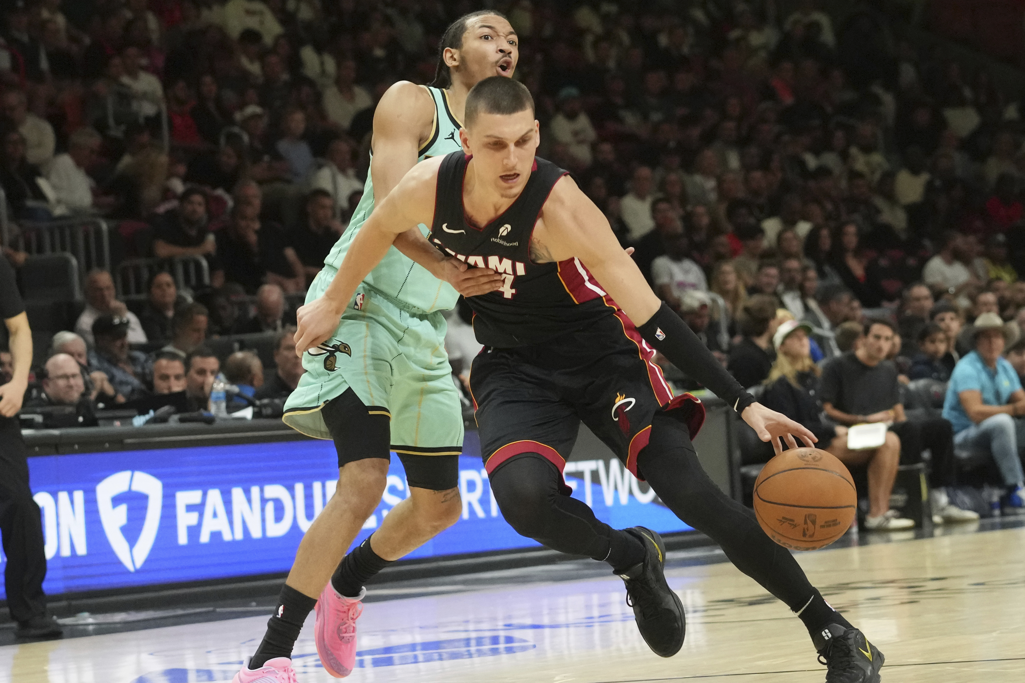 Charlotte Hornets guard Nick Smith Jr. (8) defends Miami Heat guard Tyler Herro (14) during the first half of an NBA basketball game, Sunday, March 23, 2025, in Miami.