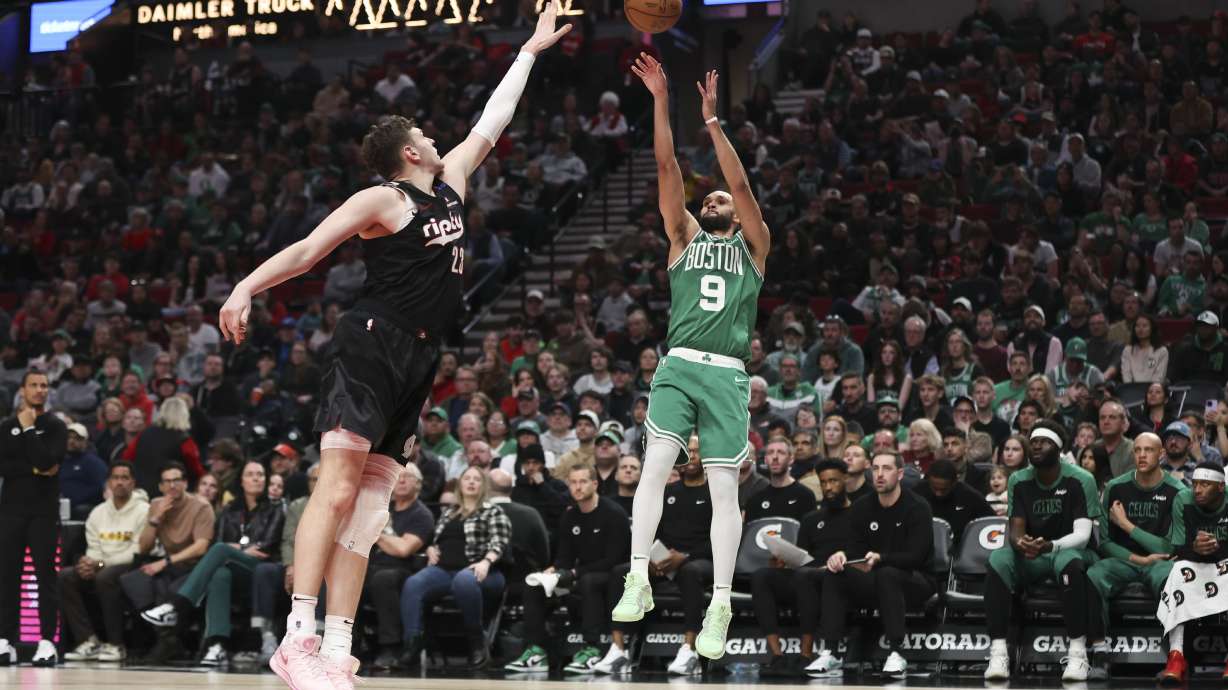 Boston Celtics guard Derrick White (9) shoots over Portland Trail Blazers center Donovan Clingan (23) during the first half of an NBA basketball game Sunday, March 23, 2025, in Portland, Ore.