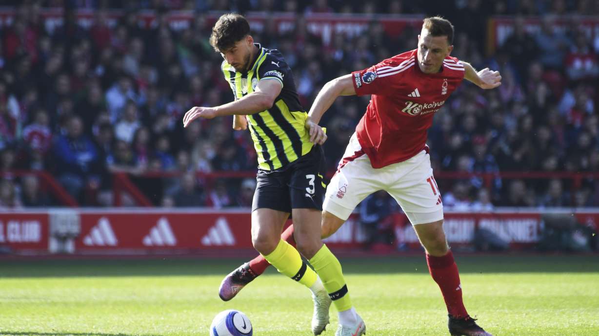Nottingham Forest's Chris Wood, right, and Manchester City's Ruben Dias vie for the ball during the English Premier League soccer match between Nottingham Forest and Manchester City at the City Ground stadium, in Nottingham, England, Saturday, March 8, 2025.