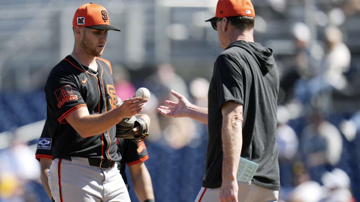 San Francisco Giants manager Bob Melvin, right, takes the ball from Giants starting pitcher Landen Roupp during the fourth inning of a spring training baseball game against the San Diego Padres, Tuesday, March 4, 2025, in Peoria, Ariz.