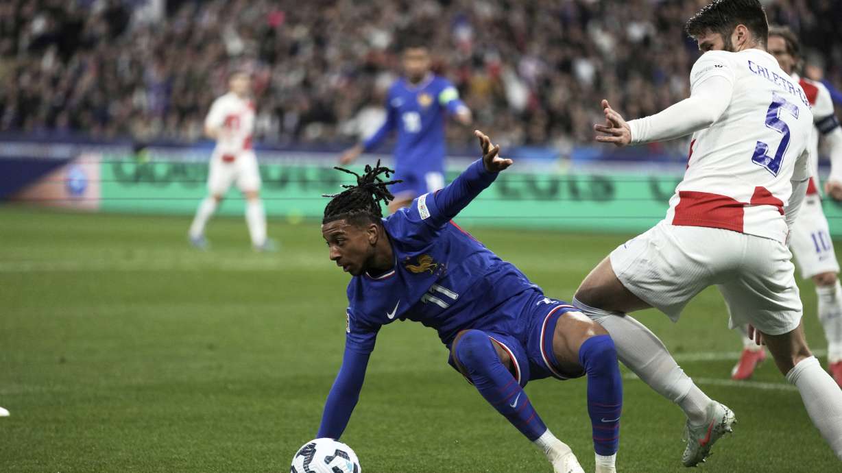 France's Michael Olise, left, and Croatia's Duje Caleta-Car vie for the ball during the UEFA Nations League quarterfinal second leg soccer match between France and Croatia, at the Stade de France in Saint-Denis, outside Paris, Sunday, March 23, 2025.