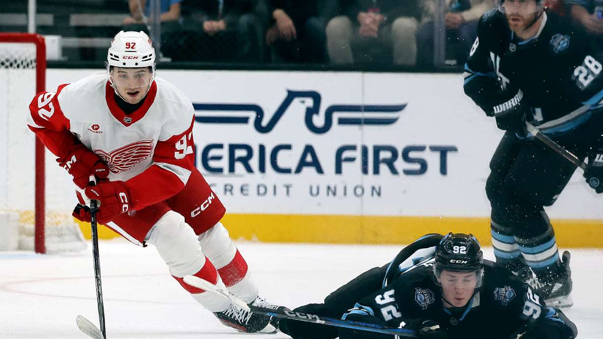 Utah Hockey Club center Logan Cooley (92) falls as Detroit Red Wings center Marco Kasper (92) takes possession of the puck during an NHL game at the Delta Center in Salt Lake City on Monday, March 24, 2025.