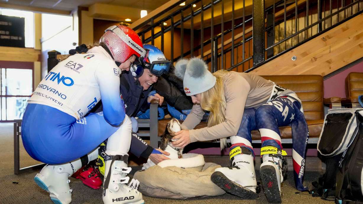 FILE - Lindsey Vonn, right, pets her dog Lucy with fellow skiers after a training session at Copper Mountain Ski Resort in Copper Mountain, Colo., Friday, Dec. 6, 2024.