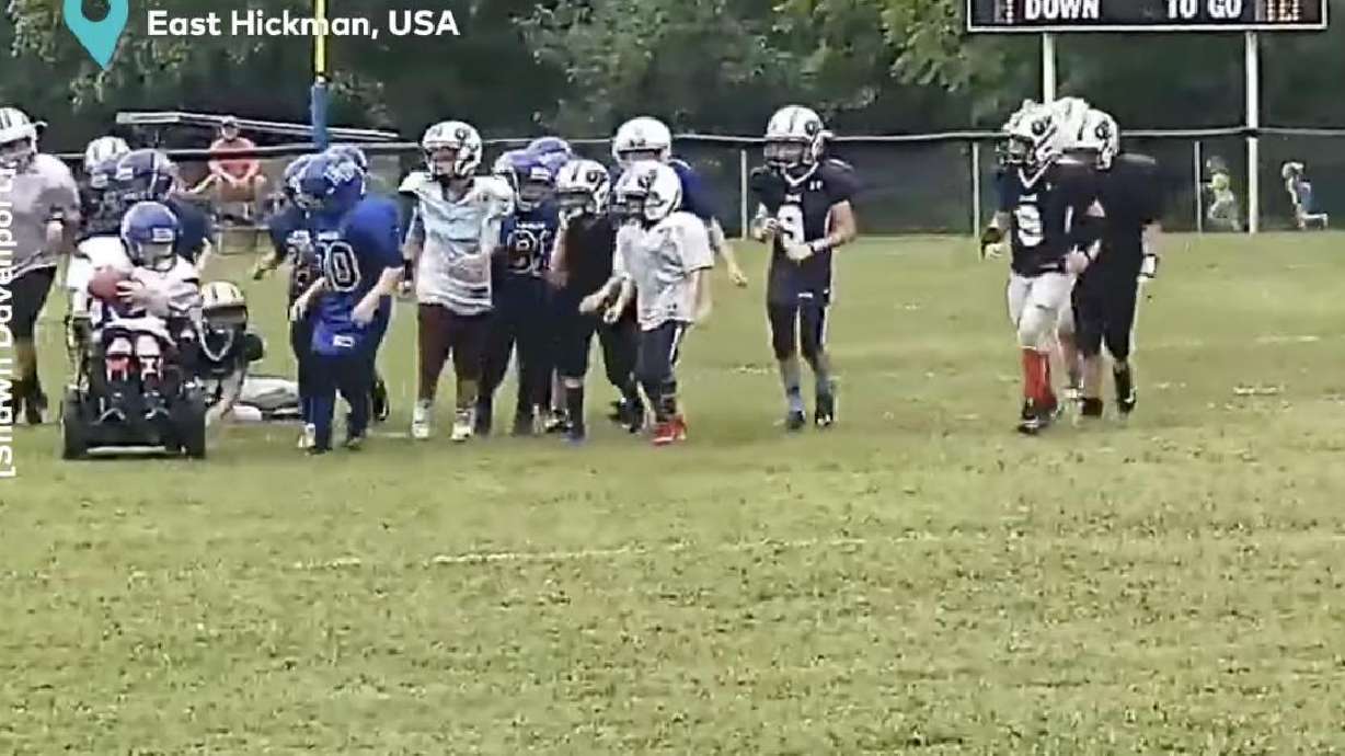 A little league football team in East Hickman, Tennessee, cheers on a wheelchair-bound teammate as he motors toward an honorary touchdown.