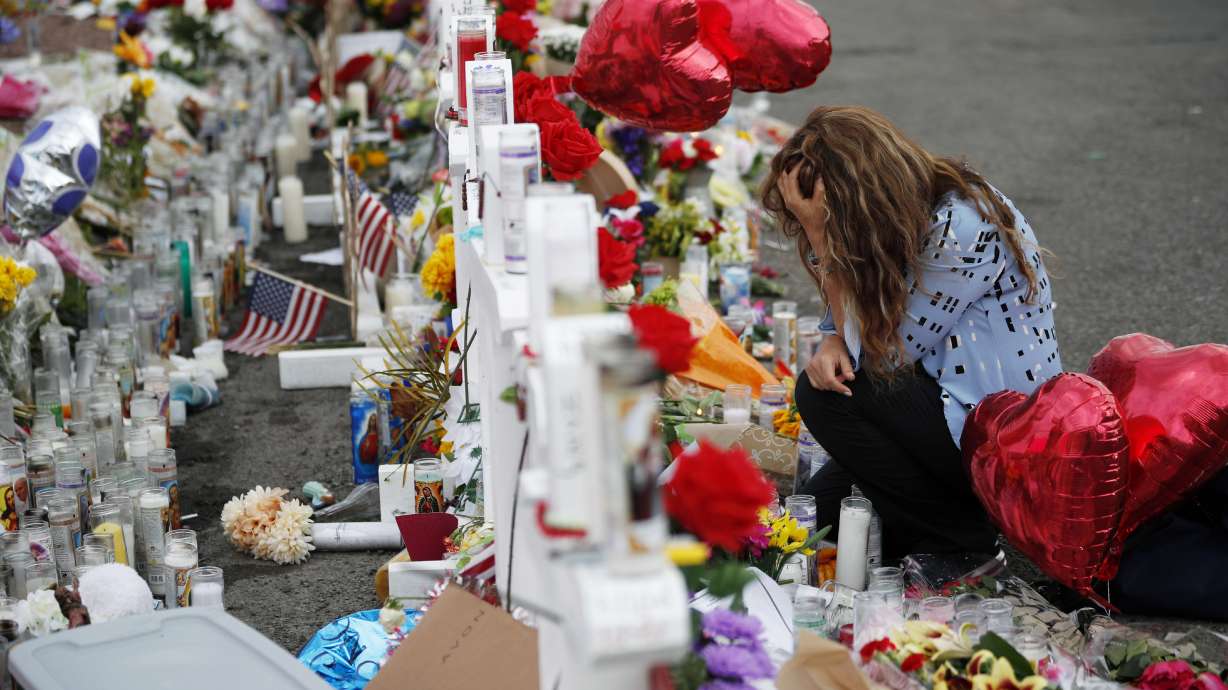 Gloria Garces kneels in front of crosses at a makeshift memorial near the scene of a mass shooting at a shopping complex in El Paso, Texas, on Aug. 6, 2019. The gunman who killed 23 people has been offered a plea deal to avoid the death penalty.