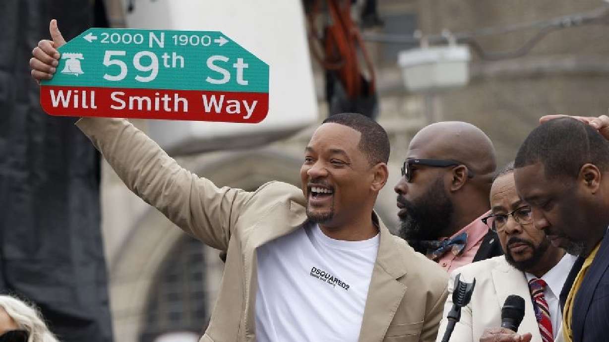 Will Smith holds up a street sign during a ceremony to name a street after him in West Philadelphia on Wednesday.