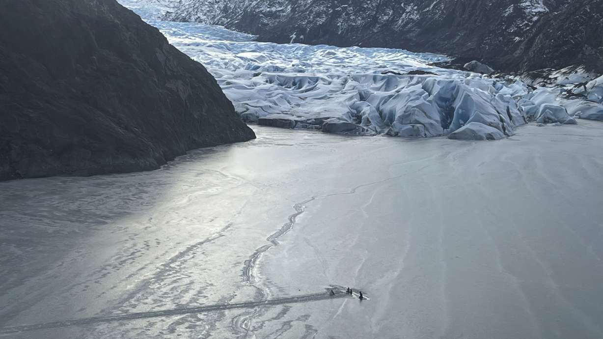 An airplane is partially submerged into the ice of Tustumena Lake at the toe of a glacier on Monday near Soldotna, Alaska. A pilot rescued with two young family members was a student pilot not authorized to have passengers, officials said Wednesday.