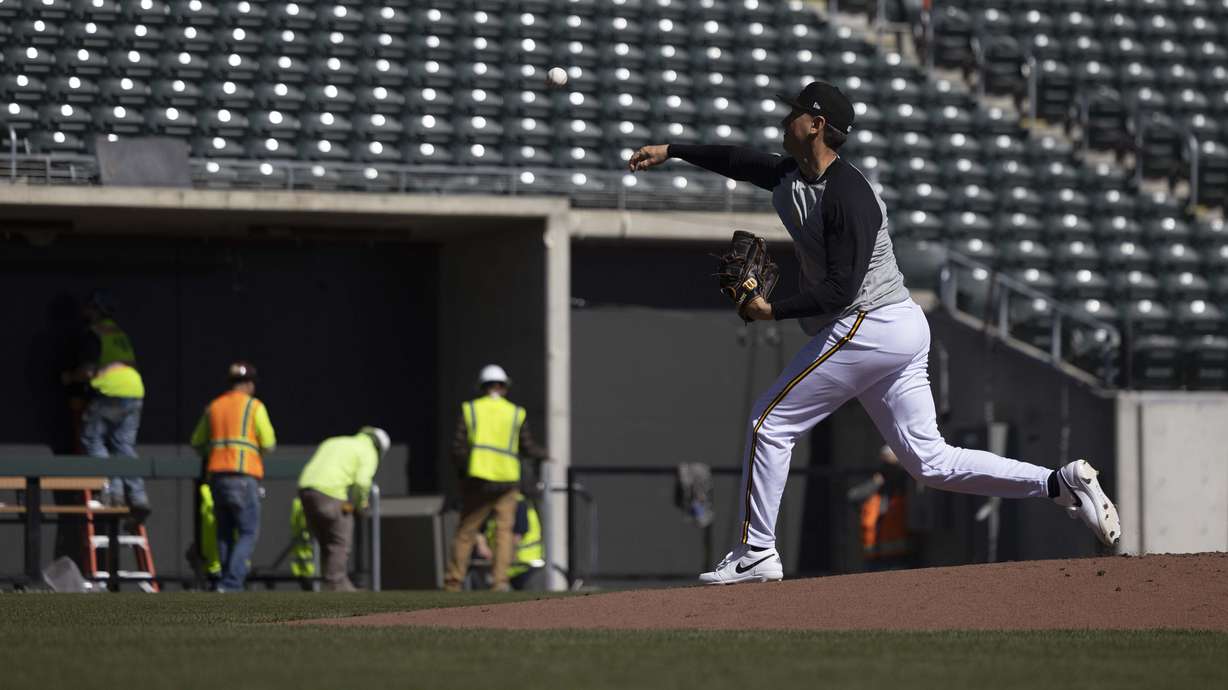A Salt Lake Bees pitcher practices while construction continues on the Bees' new baseball stadium, The Ballpark at American First Square in South Jordan on Wednesday.