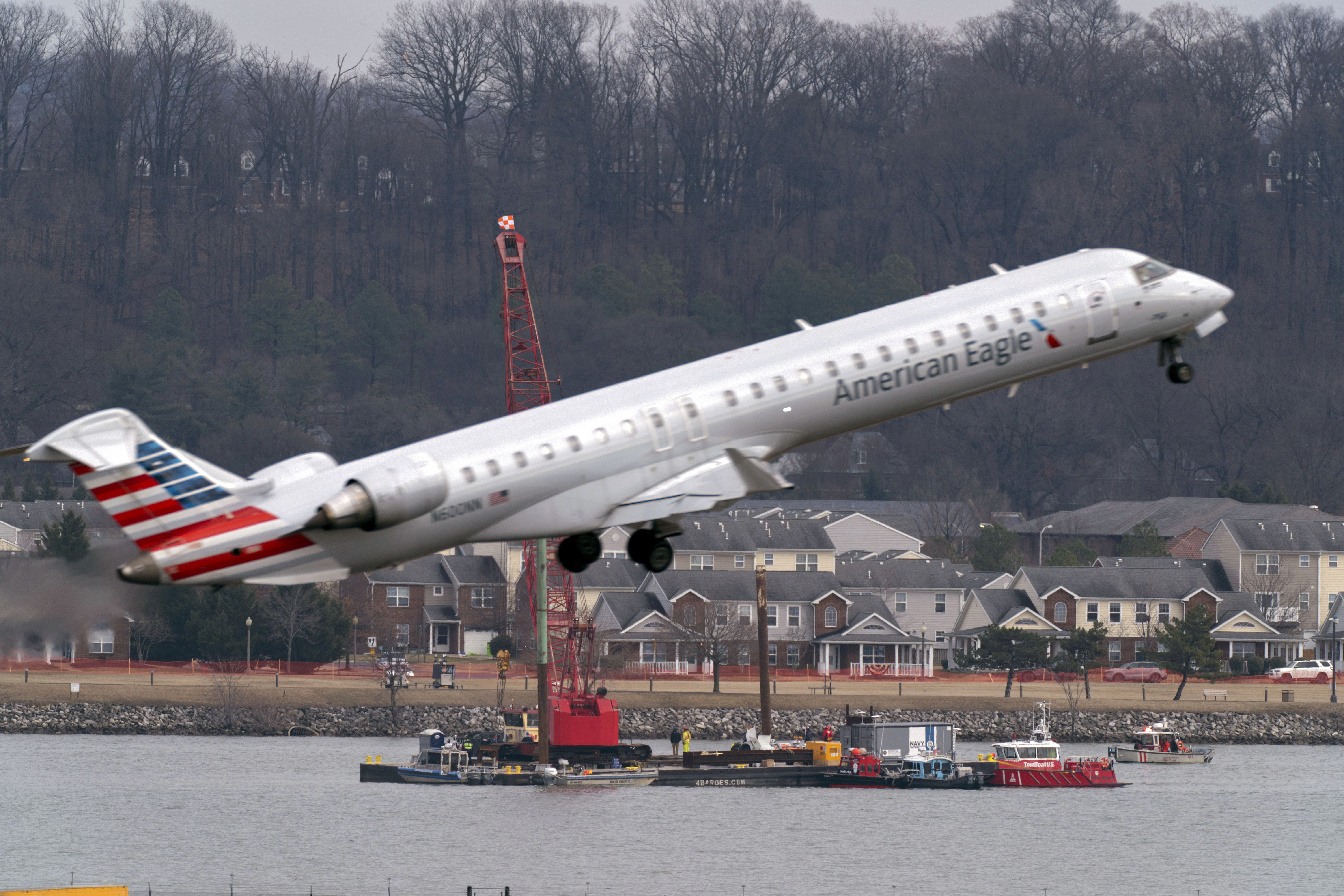 Salvage crews work on recovering wreckage near the site in the Potomac River of a mid-air collision between an American Airlines jet and a Black Hawk helicopter at Ronald Reagan Washington National Airport, Thursday, Feb. 6, 2025, in Arlington, Va.