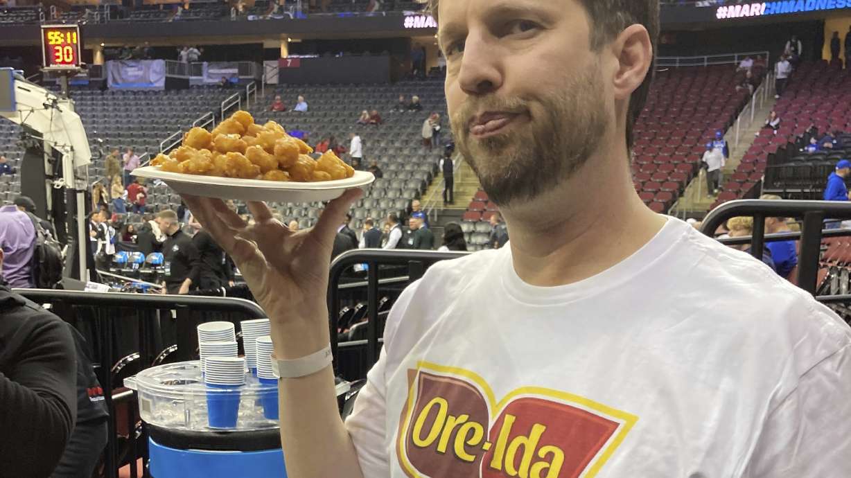 Actor Jon Heder prepares to serve a plate of tater tots ahead of BYU's game in the NCAA college basketball tournament, Thursday, March 27, 2025, in Newark, N.J.