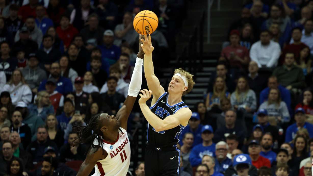 Brigham Young Cougars forward Richie Saunders (15) passes the ball over Alabama Crimson Tide center Clifford Omoruyi (11) during the first half of an NCAA Sweet 16 basketball game at the Prudential Center in Newark, N.J., on Thursday, March 27, 2025.