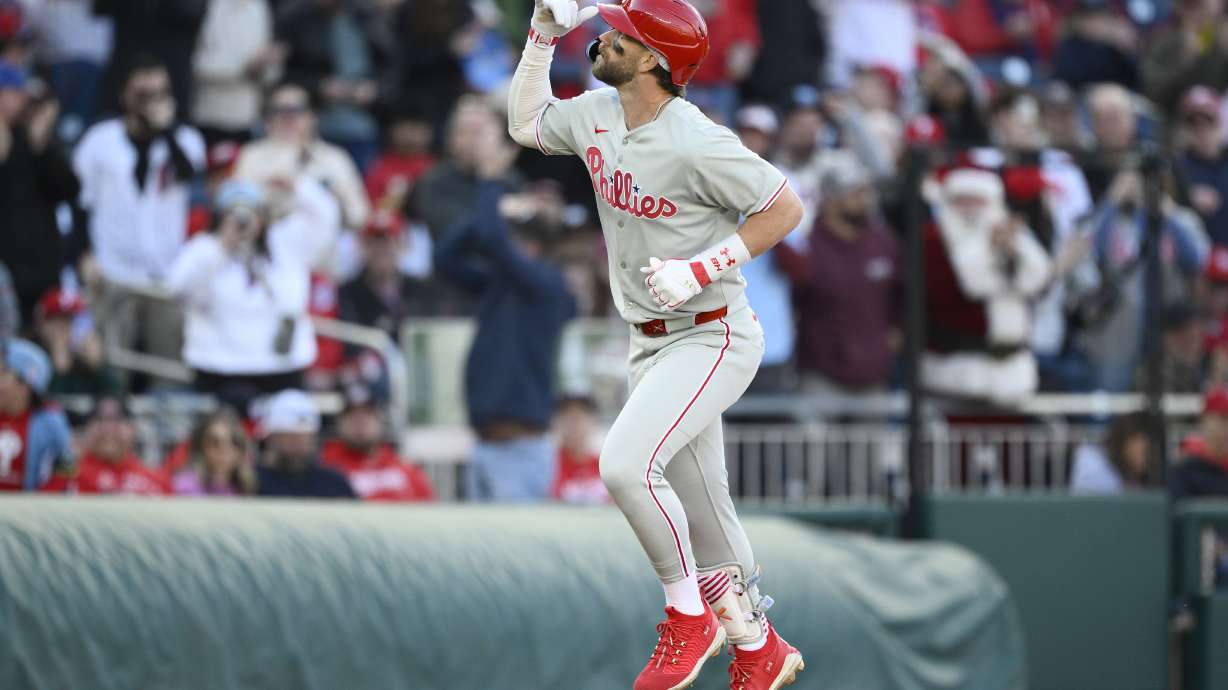 Philadelphia Phillies' Bryce Harper celebrates as he rounds the bases on his home run in the seventh inning of an opening-day baseball game against the Washington Nationals, Thursday, March 27, 2025, in Washington.
