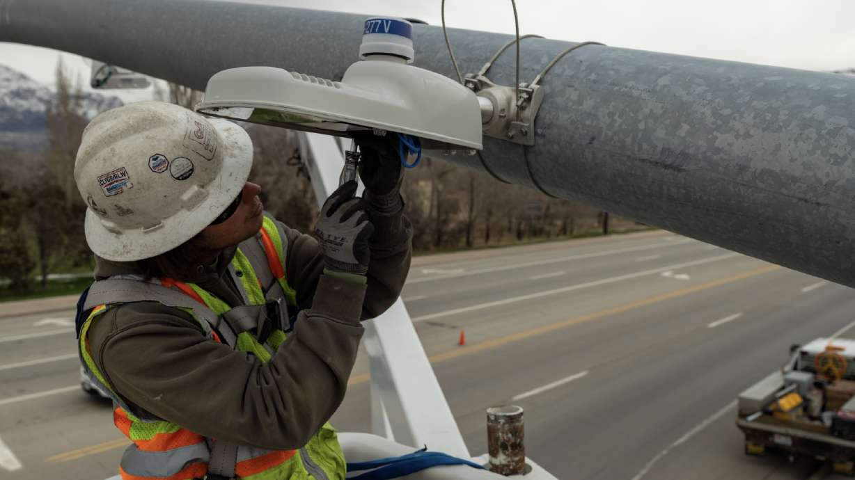 Utah Department of Transportation crews install an undermast light in Roy. The agency said Friday it has installed about 150 of these lights across the state in an effort to improve pedestrian safety.