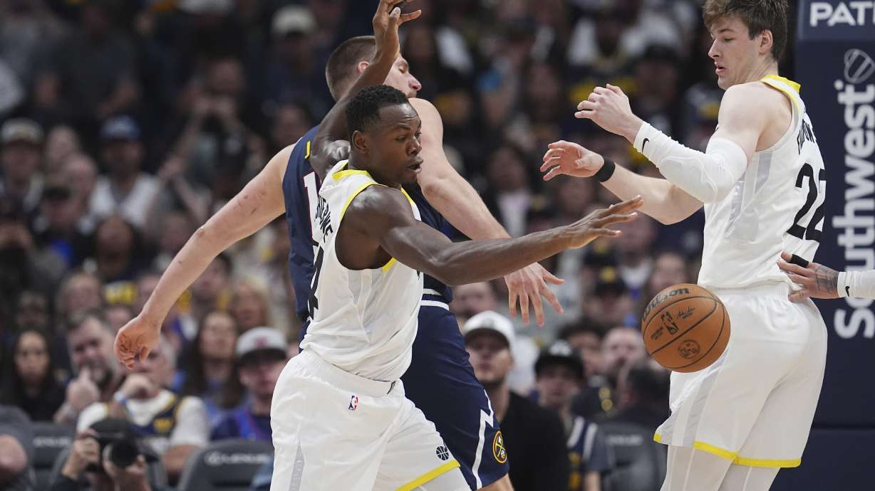 Utah Jazz center Oscar Tshiebwe, front left, reaches out for the ball after stealing it from Denver Nuggets center Nikola Jokic, back left, as Jazz forward Kyle Filipowski looks on in the second half of an NBA basketball game Friday, March 28, 2025, in Denver.