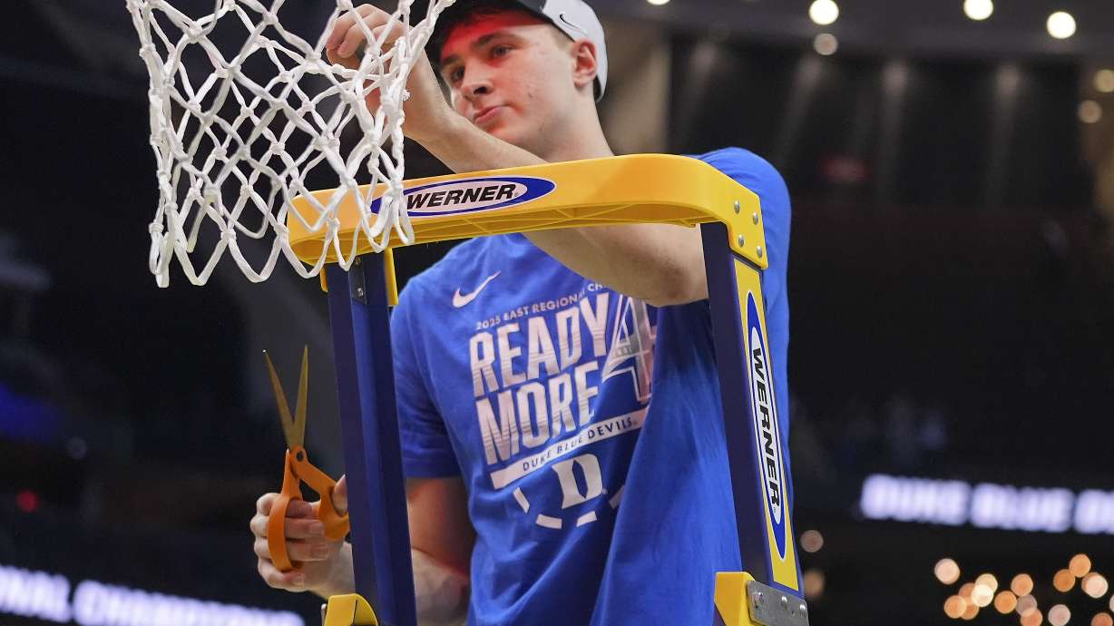 Duke forward Cooper Flagg (2) cuts a piece of the net after Duke defeated Alabama in an Elite Eight round NCAA college basketball tournament game, Saturday, March 29, 2025, in Newark, N.J.