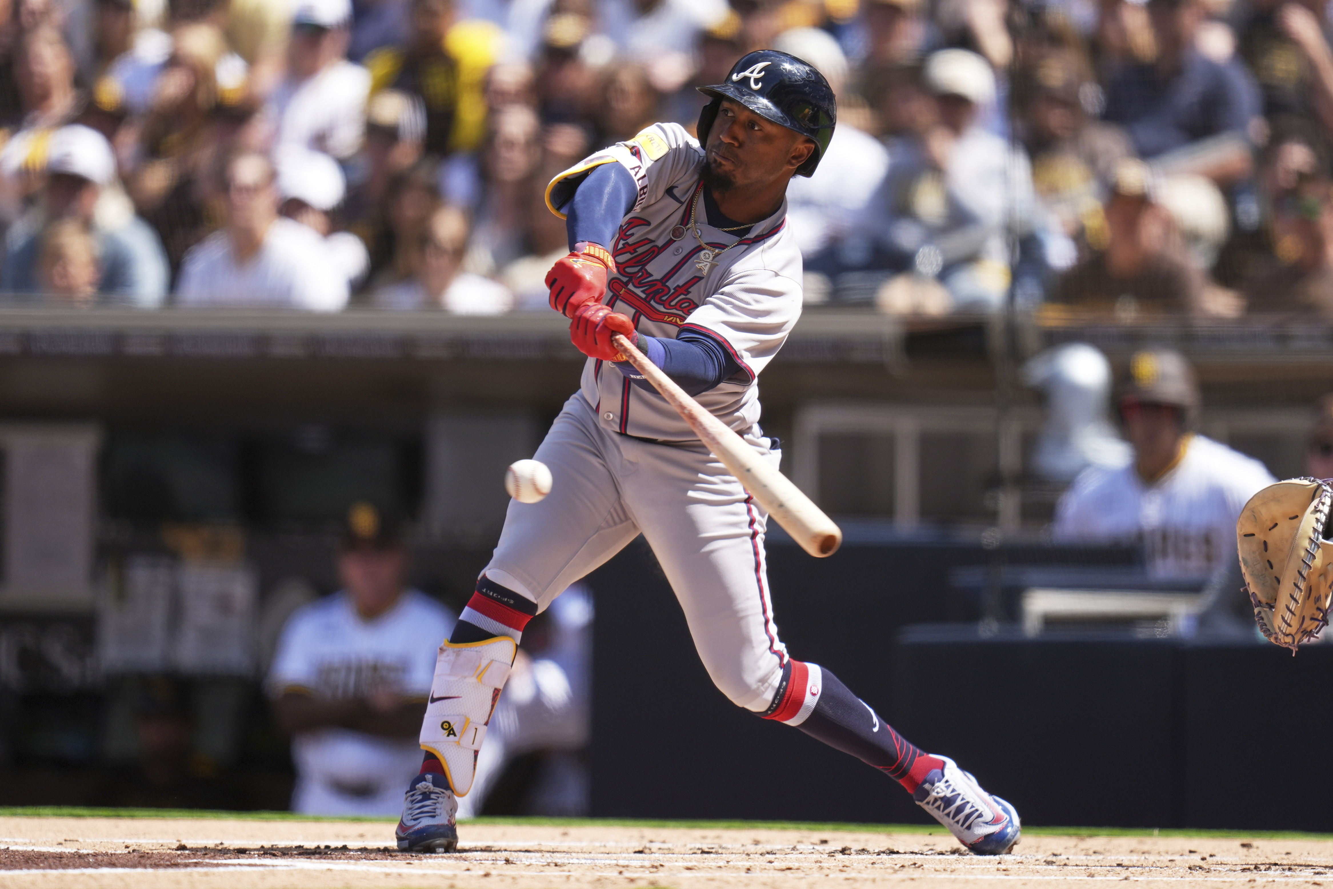 Atlanta Braves' Ozzie Albies hits into a force out during the first inning of an opening-day baseball game against the San Diego Padres Thursday, March 27, 2025, in San Diego. Atlanta Braves' Jurickson Profar scored from third base on the play.
